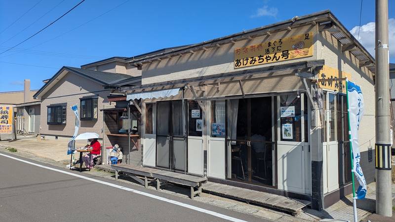 大間の道沿いに建つ、あけみちゃん号の看板を掲げた小さな店舗